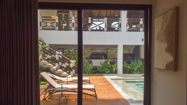 Une terrasse en bois avec des chaises longues et une piscine.