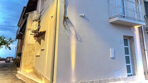 A building with a stone facade, a balcony with metal railings, and a satellite dish on the roof. - Dimore Diffuse R H (Rende)