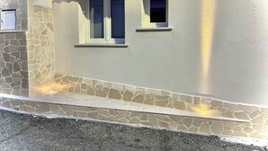 A building with a stone facade, two windows, and a small attached structure with a tiled roof. - Dimore Diffuse R H (Rende)