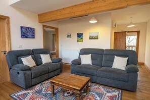 A living room with two grey sofas, a wooden coffee table, and a patterned rug.