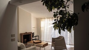 Un salon avec une cheminée, un canapé, une table basse et un fauteuil.
