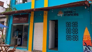 Un edificio de dos pisos con fachada azul y rayas verticales amarillas.