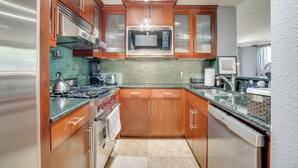 Una cocina moderna con armarios de madera, electrodomésticos de acero inoxidable y un salpicadero de azulejos.