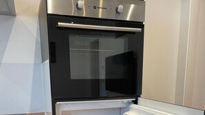 A modern kitchen with a built-in oven and a refrigerator with clear storage bins.