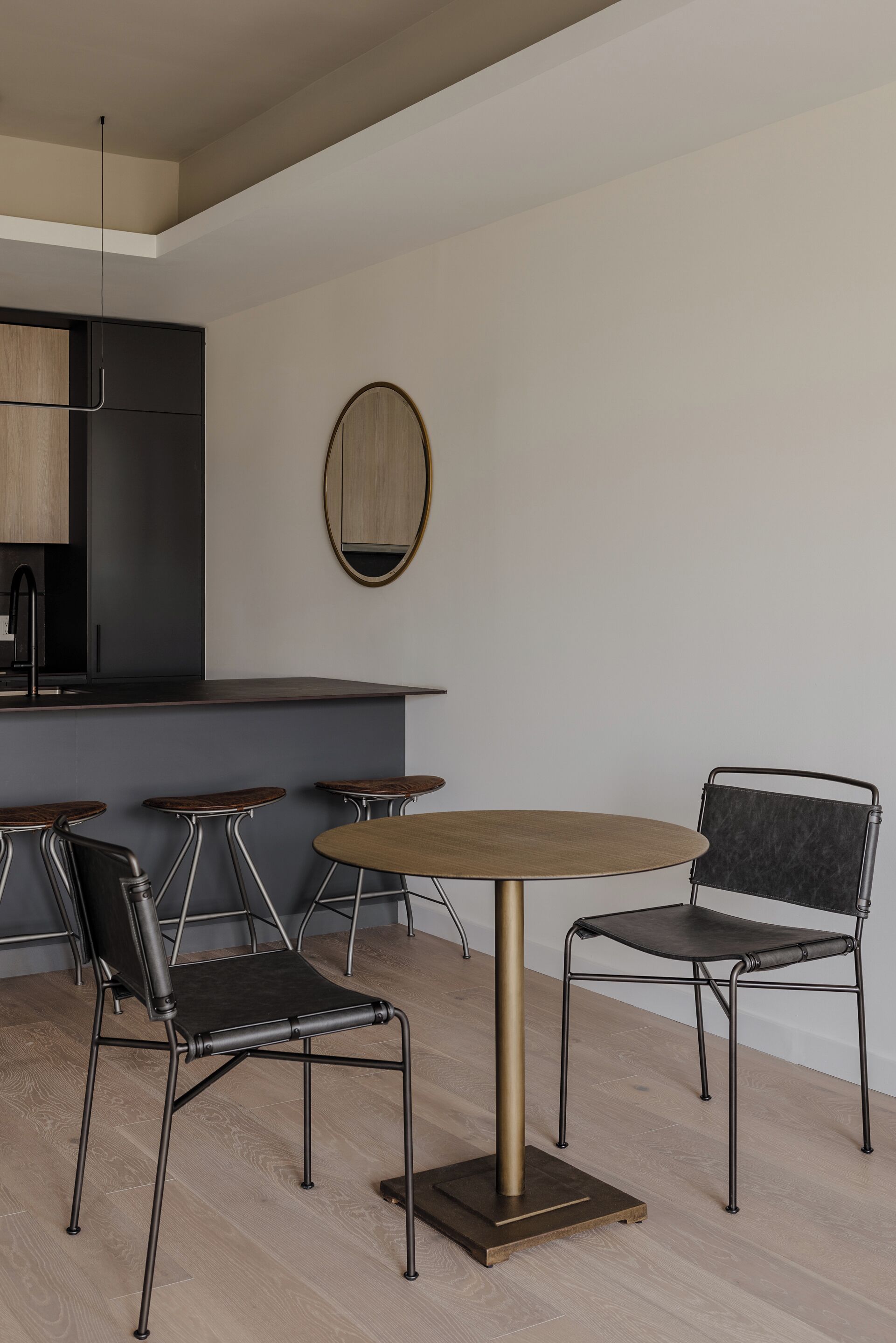 Una cucina moderna con isola centrale, sgabelli da bar e un tavolo rotondo con sedie.