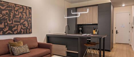 A modern apartment with a living area, kitchenette, and a dining space.