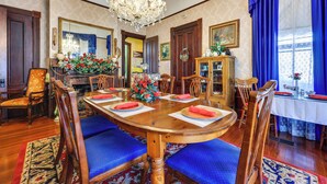 A formal dining room with a wooden table, blue upholstered chairs, and a chandelier. - 'Grand Gables' Home: 1 Block to St Johns River! (Palatka)
