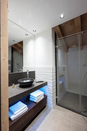 A modern bathroom with a black vessel sink, a glass shower enclosure, and a wooden ceiling. - MGM Hôtels et Résidences - Residence Anitea (Les Avanchers-Valmorel)
