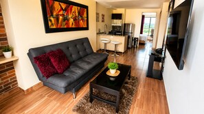 Una sala moderna con un sofá, una mesa de centro y un televisor.