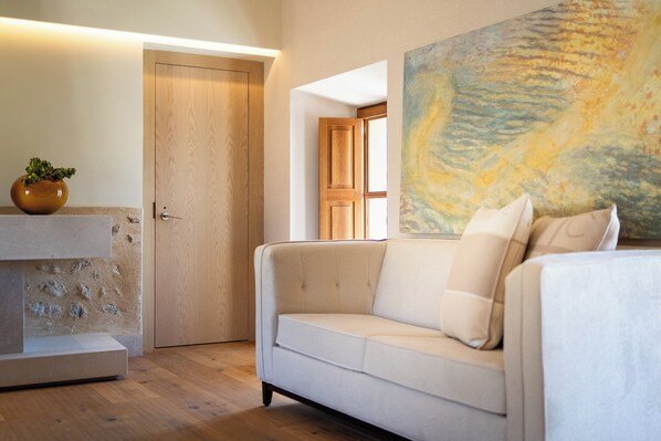 Un salon moderne avec un canapé beige, une porte en bois et un tableau accroché au mur.