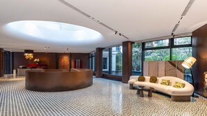 Un hall d’entrée moderne avec un comptoir d’accueil, un canapé et de grandes fenêtres.