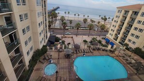 A hotel with a swimming pool, outdoor seating, and a view of the beach and ocean. - Wyndham Oceanside Pier Resort - 3 Bedroom Ocean View Presidential Suite - Ocean (Oceanside)