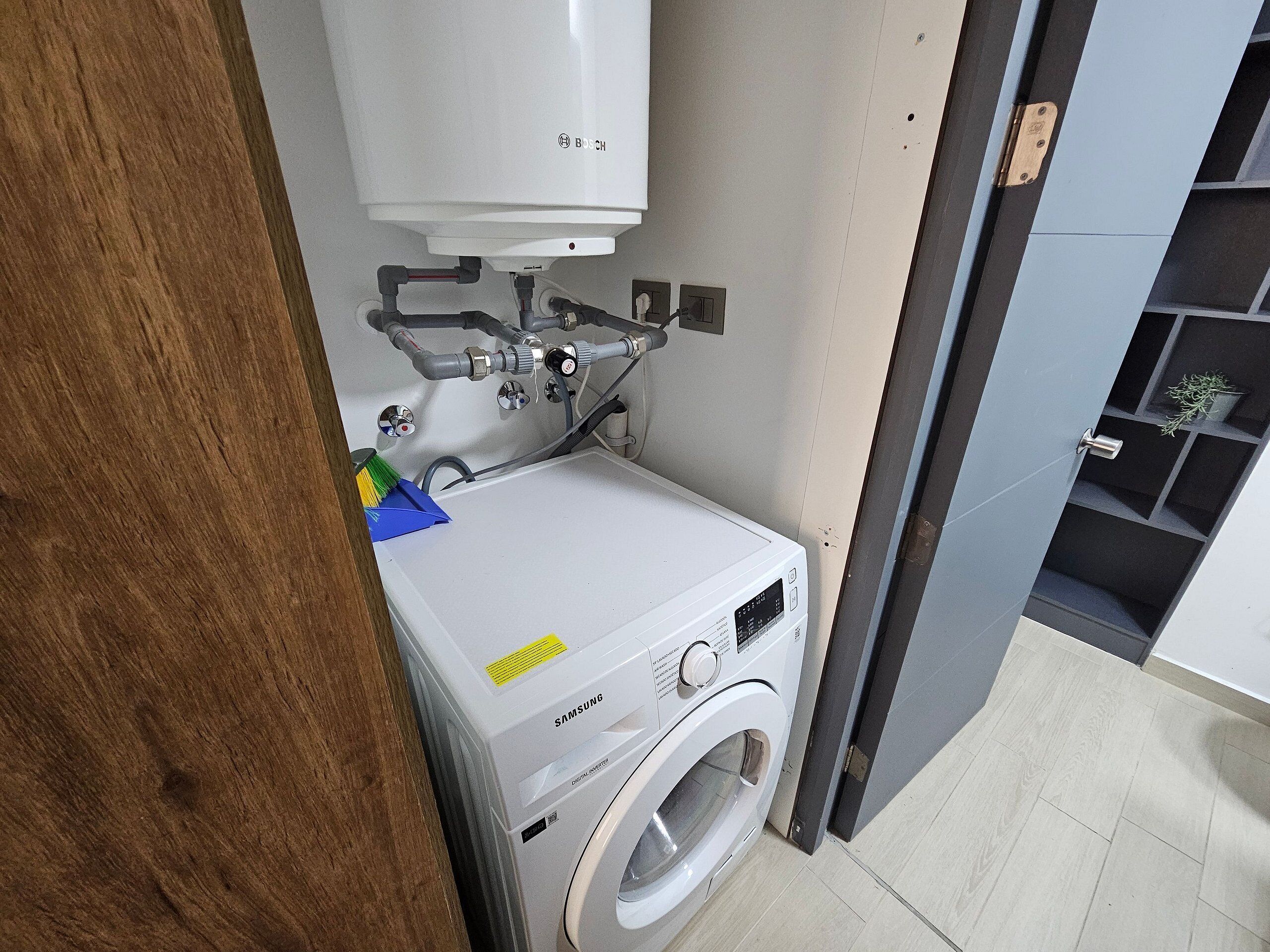Un lavadero pequeño y moderno con una lavadora Bosch y una secadora Samsung.