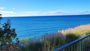A coastal view with a railing, clear sky, and calm sea. - Front line beach Benalmádena La Perla Playa Paraíso (BENALMÁDENA)