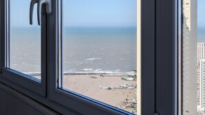 A view of a beach with a building in the background. - BT Homes - Mar del Plata, Av. Colon (Mar del Plata)