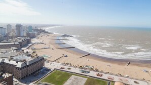 An aerial view of a coastal city with a beach, buildings, and a promenade. - BT Homes - Mar del Plata, Av. Colon (Mar del Plata)