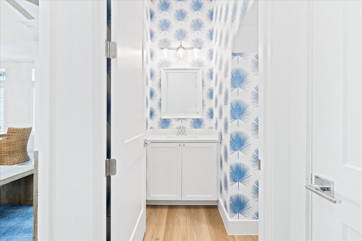 A modern bathroom with a white vanity, a mirror, and a shower area.