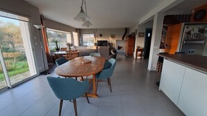 Una cocina moderna con comedor, ventanas amplias y chimenea.