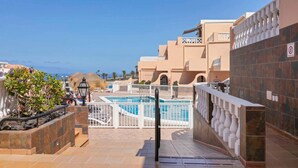 Une piscine sur le toit avec vue sur la mer, entourée d’immeubles dotés de balcons et d’un panneau indiquant qu’il est interdit de fumer.