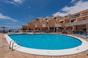 A hotel with a swimming pool, sun loungers, and a clear blue sky. - Condo in Costa Adeje · ★4.75 · 1 bedroom · 1 bed · 1 bath (Costa Adeje)