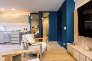A modern living room with a sofa, a coffee table, and a TV mounted on a wooden wall. - Digital Nomad Paradise ~1BR unit in Manila’s Heart (Medellín)