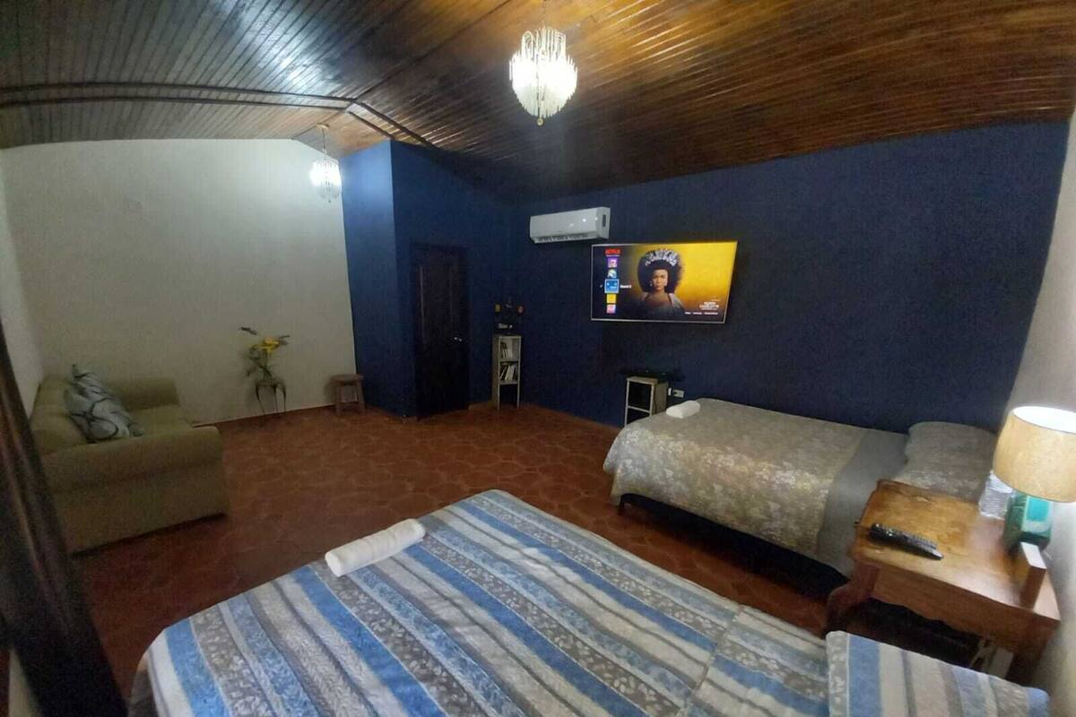 Ein Hotelzimmer mit einem Bett, einer Couch, einem Fernseher und einem kleinen Tisch mit einer Lampe.