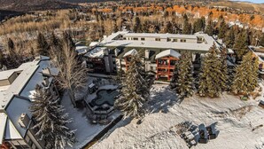 A resort with a large building, snow-covered grounds, and a mountainous backdrop. - Snowflower by Luxury Mountain Destinatio (Park City)