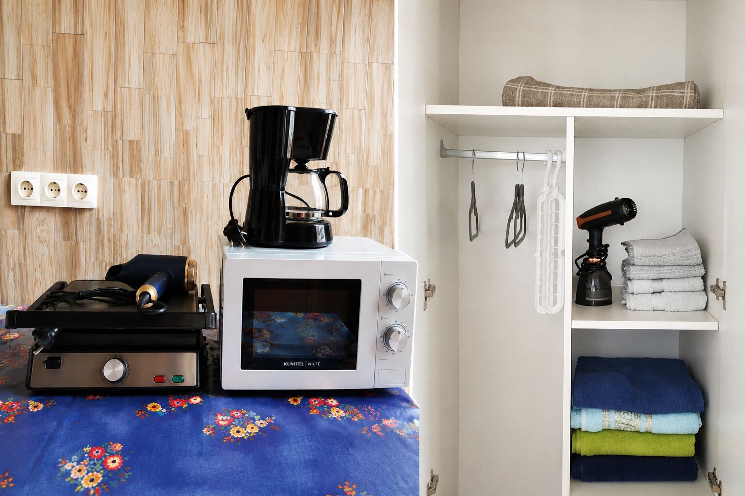 A kitchenette with a coffee maker, a microwave, and a portable heater on a table.
