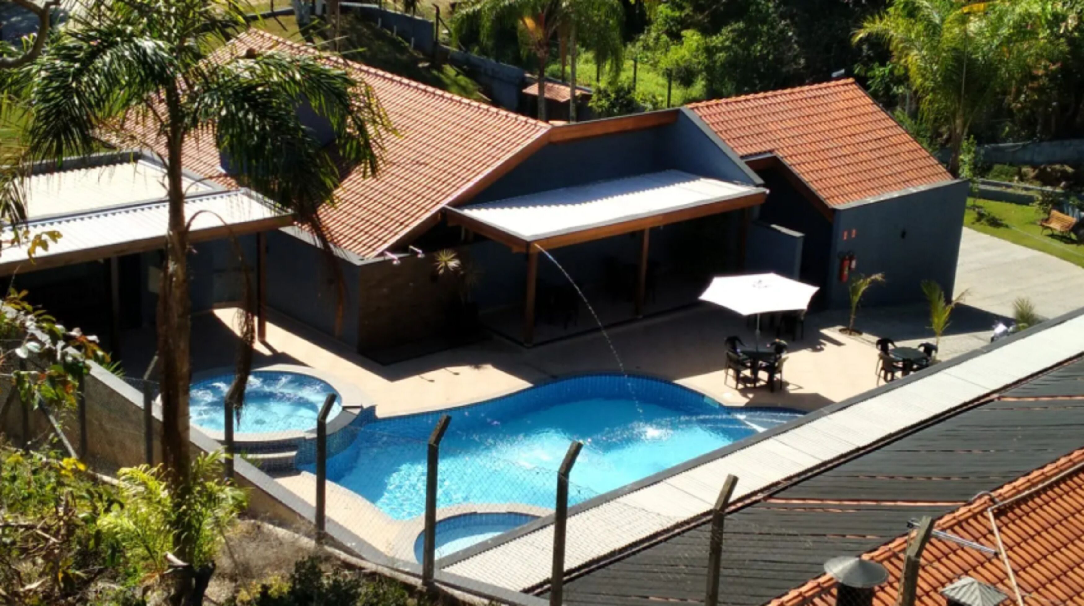 A residential property with a swimming pool, covered patio, and outdoor seating area.