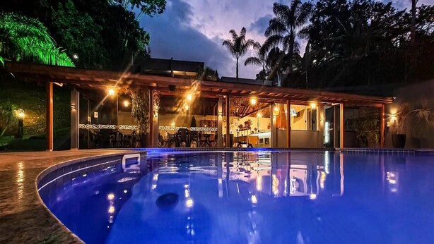 A swimming pool with a covered area and a bar. - Pousada Recanto da Cascata (Aguas de Lindoia)
