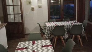 A dining area with tables covered in chevron-patterned tablecloths, green chairs, and a wooden ceiling.