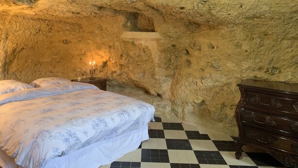 Ein Schlafzimmer mit einem Bett, einem Schminktisch und einer Steinwand.