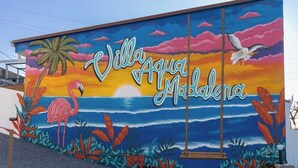 Ein Wandbild mit dem Text 'Villa Agua Madalena' und tropischen Elementen.
