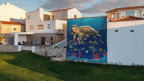 Ein modernes Haus mit einem großen Wandgemälde von einer Meeresschildkröte und Meereslebewesen an der Seite.