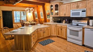 Una cocina con armarios de madera, una isla central, un microondas y un horno.
