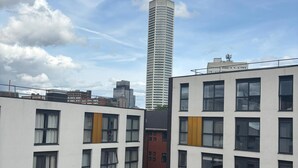 Un edificio moderno con varios pisos, ventanas amplias y una imponente torre central.