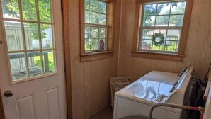 A compact bathroom with a bathtub, a window, and a door.