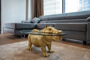 A modern living room with a sofa and a golden animal sculpture on a textured rug.