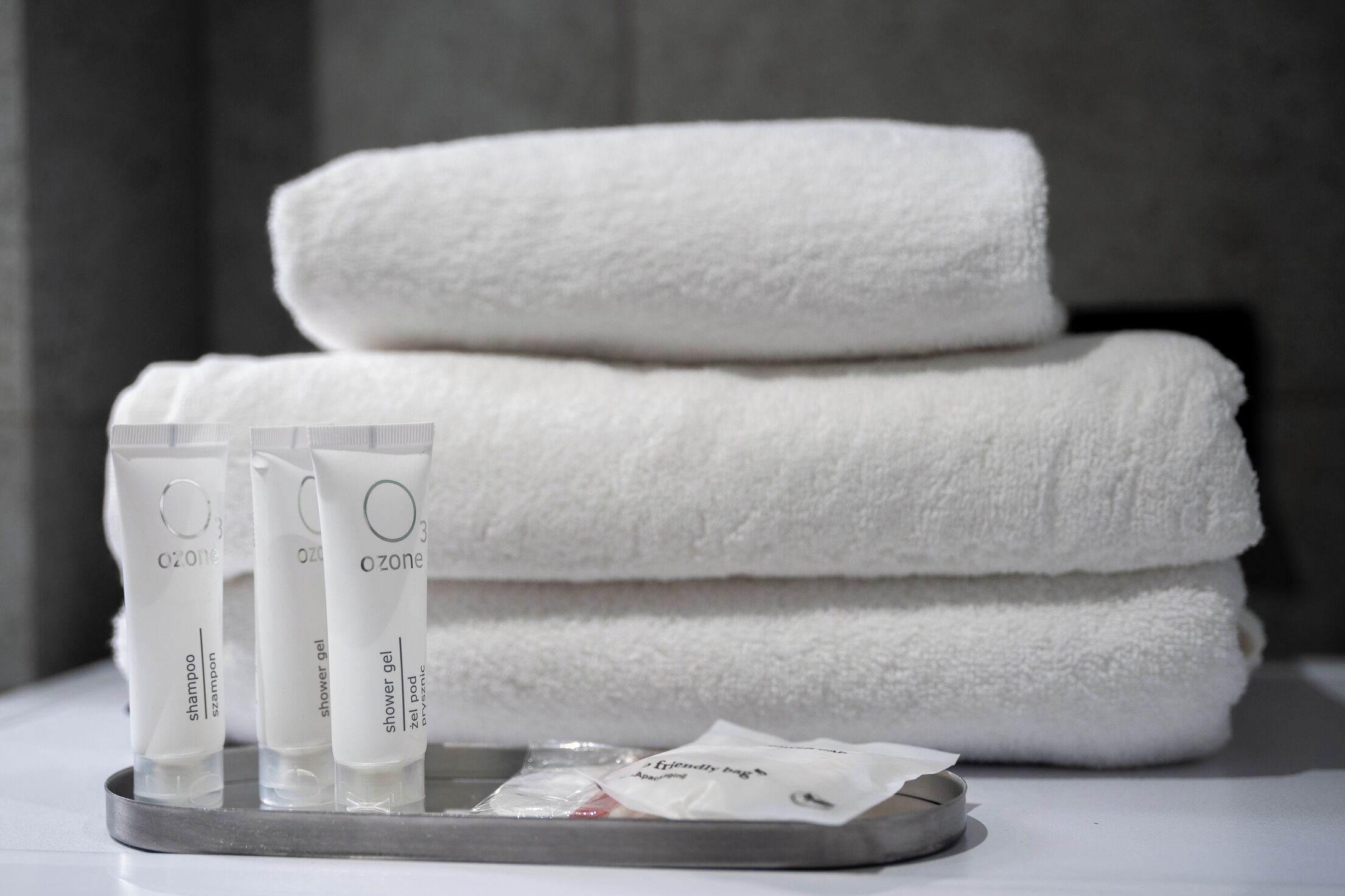 Un plateau contenant trois tubes de gel douche Ozone, un paquet de shampoing Ozone et un paquet de produit de bain Ozone.