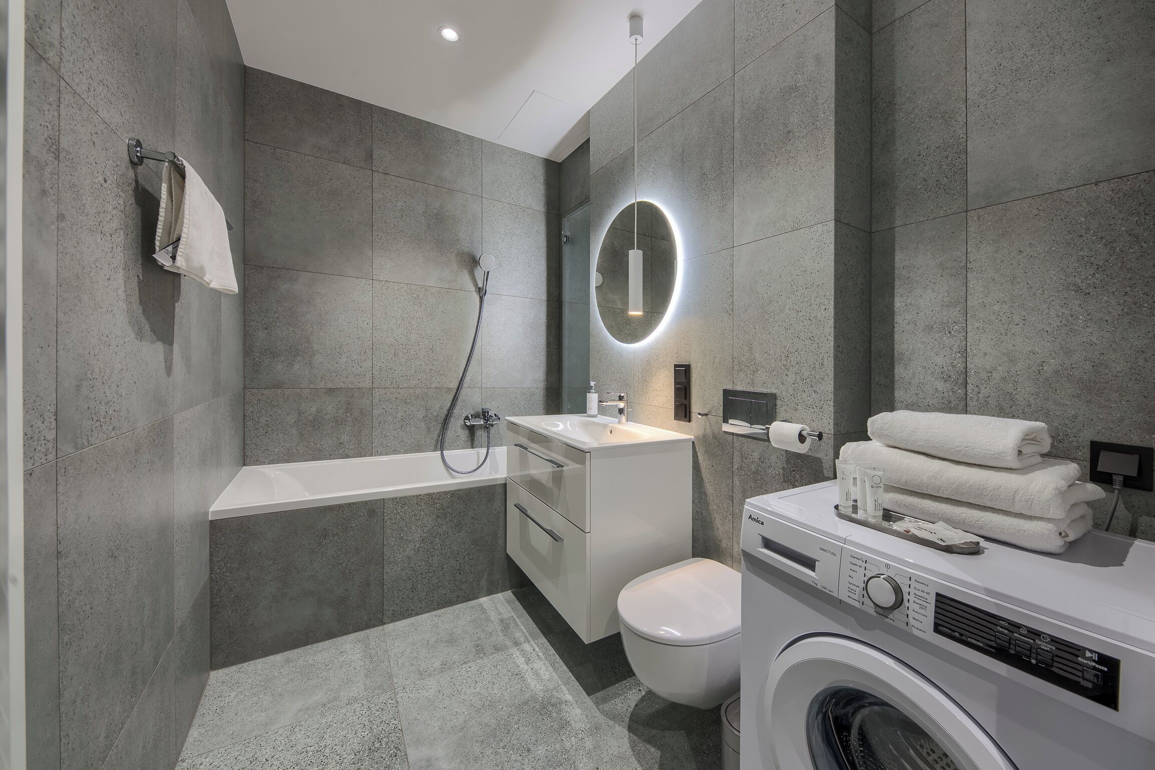 Un baño moderno con bañera, inodoro y lavadora.
