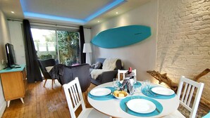 A dining area with a round table set for four, surrounded by white chairs. - Balneo 100m beach (Berck)
