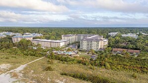 Ein Resort mit mehreren Gebäuden, einem Poolbereich und umgebender Bepflanzung.
