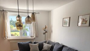 A modern living room with a sectional sofa, a coffee table, and pendant lighting.