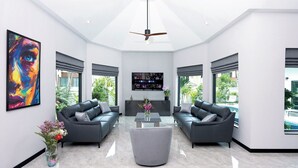 A spacious living room with two grey sofas, a coffee table, and a ceiling fan.