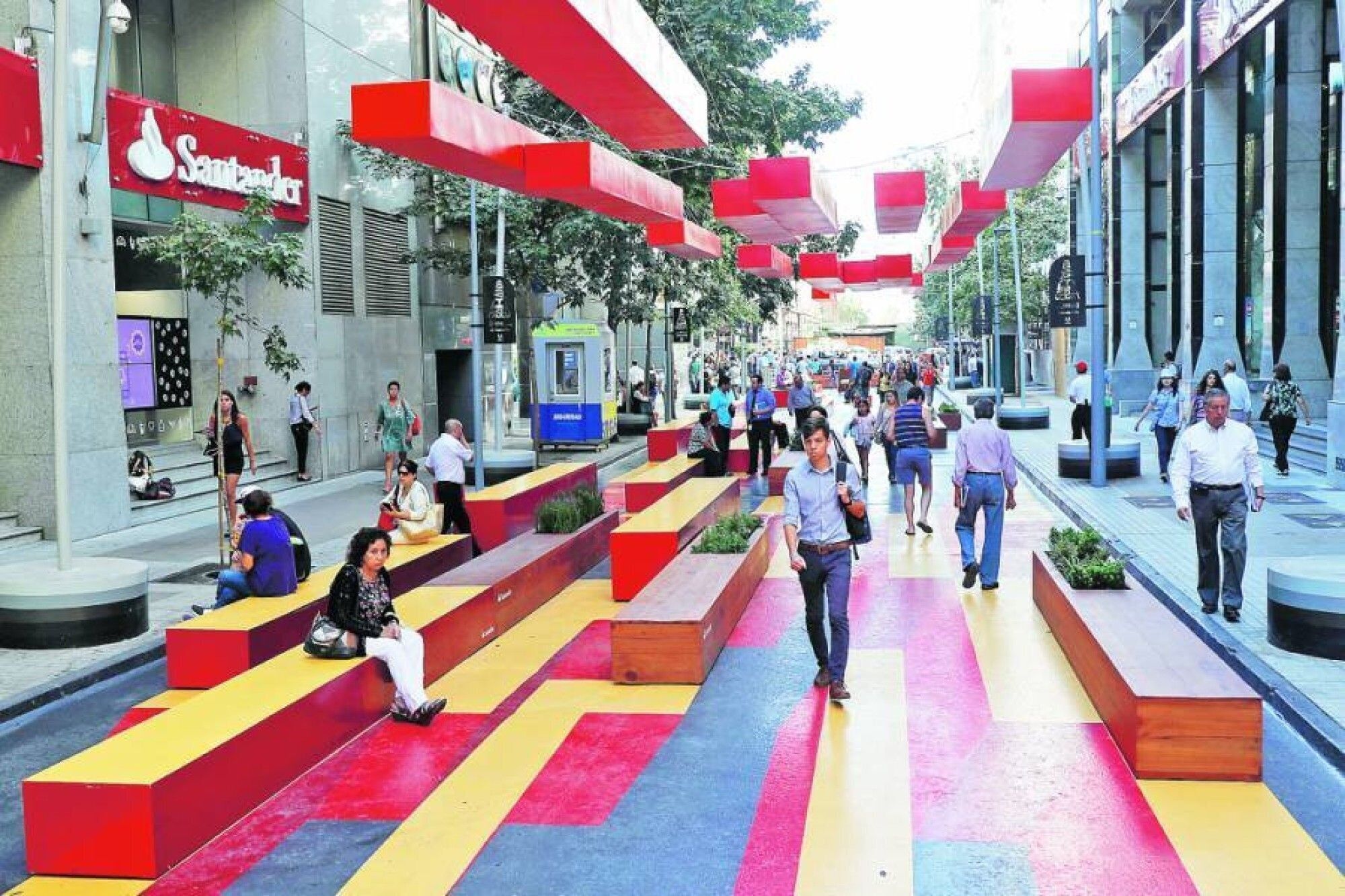 A public square with colorful seating areas and a pedestrian walkway.