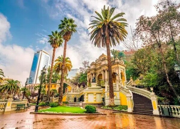 A traditional building with a central dome, surrounded by palm trees and a paved courtyard. - Condor 1152 (Santiago)