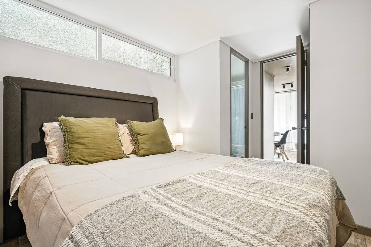 Ein Schlafzimmer mit einem großen Bett, einer Kopfteil und einem Fenster.