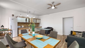 Ein modernes Wohnzimmer mit einem Holzesstisch, grau gepolsterten Stühlen und einem grauen Sofa.