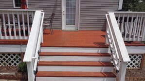A wooden staircase with white railings leading to a porch area. - A 3-Bedroom Cozy Cottage - 2 Blocks from the River (Colonial Beach)