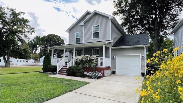 A two-story house with a covered porch and a garage. - A 3-Bedroom Cozy Cottage - 2 Blocks from the River (Colonial Beach)